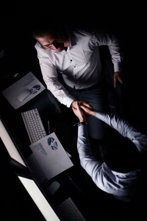 top view.a handshake with colleagues behind a Desk.の写真素材