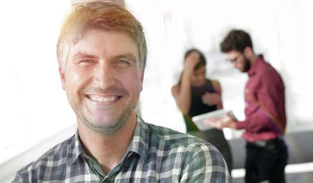 Casual businessman with arms crossed standing in the officeの写真素材