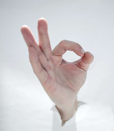 close up.male hand breaking through the paper wall and showing Oの写真素材