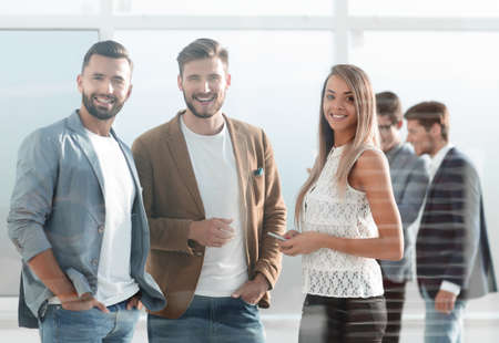 three young employees of the company standing in the officeの写真素材