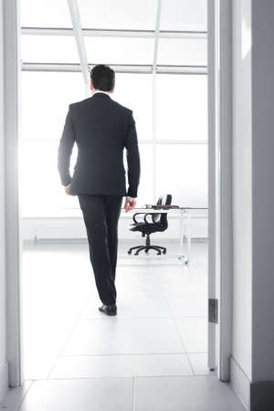 rear view.businessman walks into his office.の写真素材