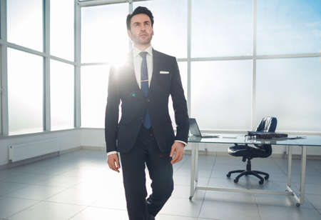 modern businessman standing in a bright officeの写真素材