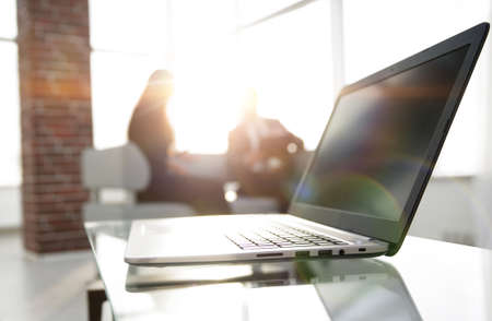 Focus on laptop on the table. Blurred people on background.の写真素材
