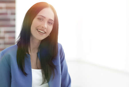 Attractive young businesswoman standing near desk in the office