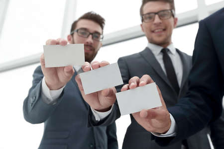 three young business partners showing their business cards.の写真素材