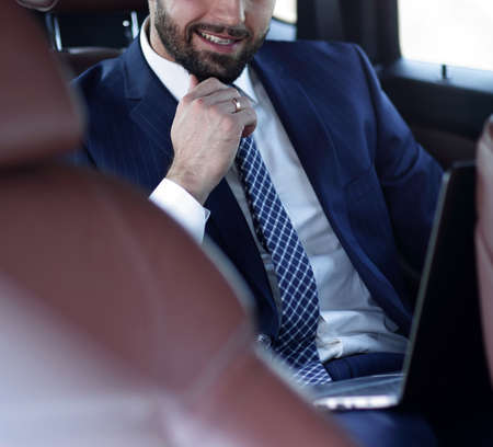 Portrait of a business man in the back seat of a car