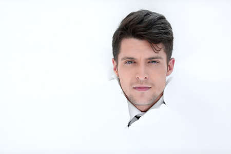 smiling businessman breaks through the paper.の写真素材