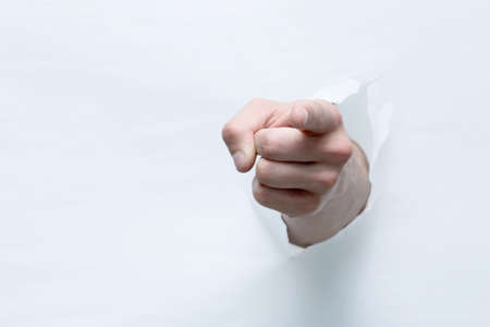 hand breaks through the paper with a gesture OK