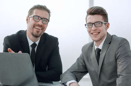 close up. smiling business partners sitting at the Desk
