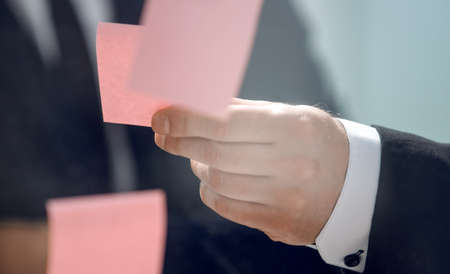 close up.business colleagues reading notes on glass