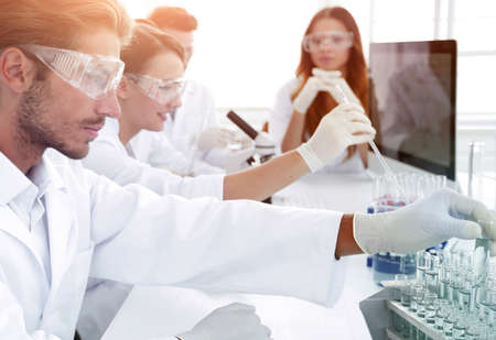 Scientists working with a microscope and make notes in the workplaceの写真素材