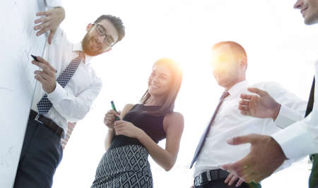 business man showing something on a whiteboard to his colleaguesの写真素材