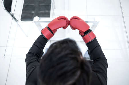 close up. businessman in red gloves sitting at a glass tableの写真素材