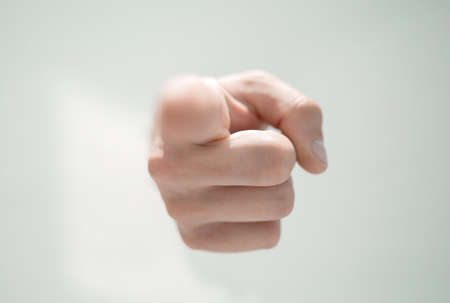 close up.a mans hand breaking through the paper and pointing soの写真素材