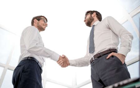 bottom view.handshake business partners standing in the office