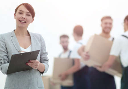 Woman manager holding clipboard on blurred background with mover