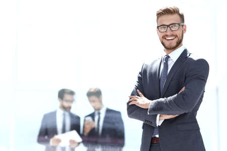 smiling businessman on blurred office background