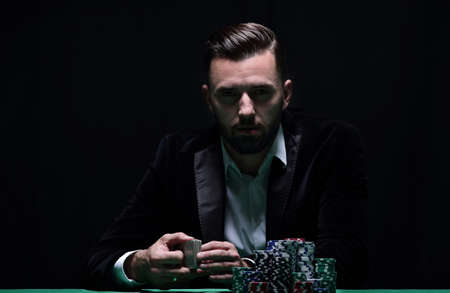 A wealthy man playing poker with the excitement in a casino.の写真素材