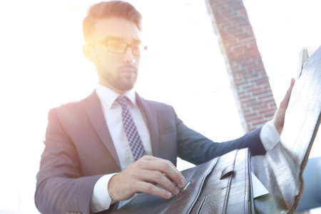 businessmans hand with suitecase in a modern office