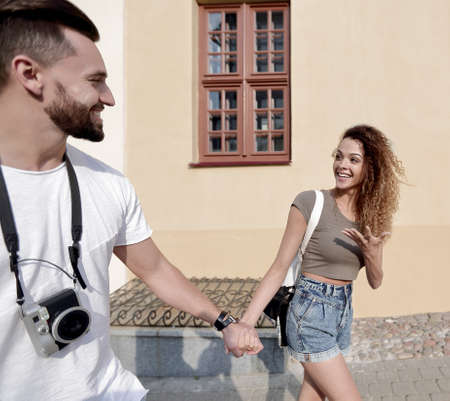 Couple of tourists look at each other and walkingの写真素材