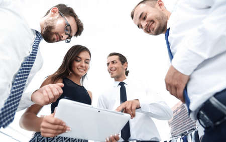 Business people in office having conversation and using digital tablet.