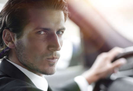 man sitting behind the wheel of a carの写真素材