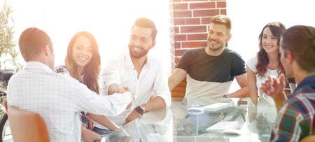 handshake of business partners sitting at the table