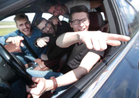 side view . friends sitting in the car and looking at the camera.の写真素材