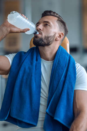 attractive man drinking bottled water in the gymの写真素材