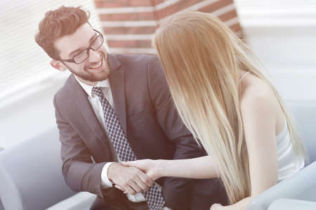 handshake of manager and client sitting in the office lobby.