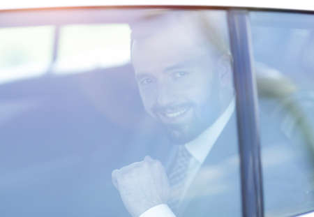 Because of a glass of smiling businessman in the back seat of a car.