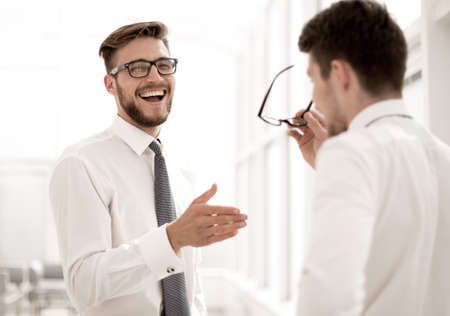 close up. employees talk, standing in a spacious officeの写真素材