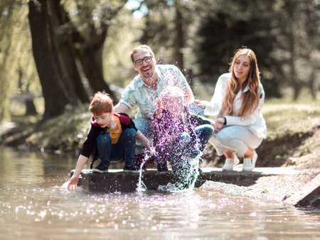 parents with children relax near the lake in the Park.の写真素材