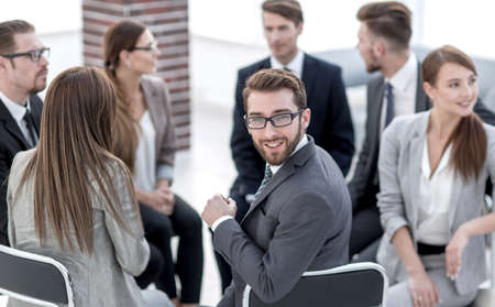 young employee sitting in a circle of colleagues
