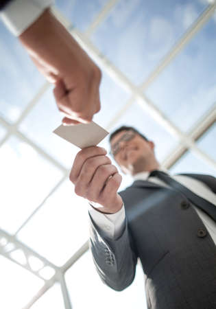 bottom view.smiling businessman takes a business card.の写真素材