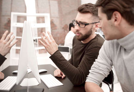 business team is discussing something sitting at the Desk