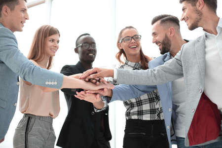 happy business team makes a tower out of hands