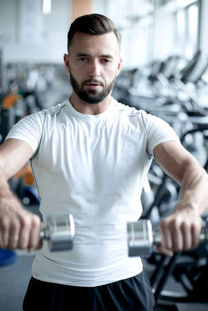 close up.stylish young man working with dumbbells in the gym.