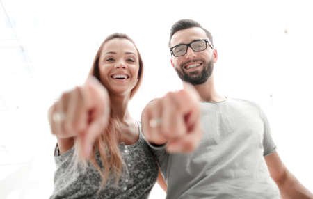 close up.happy couple pointing at you.