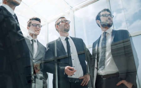 group of business people looking through the office windowの写真素材