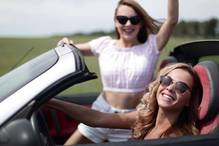 close up.two happy young women in a convertible carの写真素材