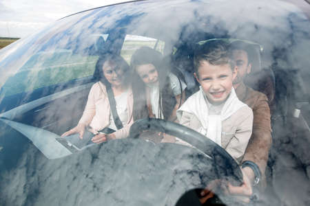 happy father and son behind the wheel of a car