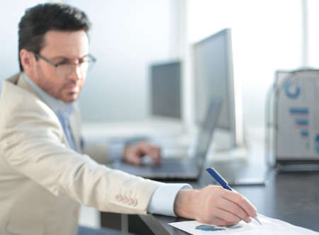 businessman writing down information in a notebook