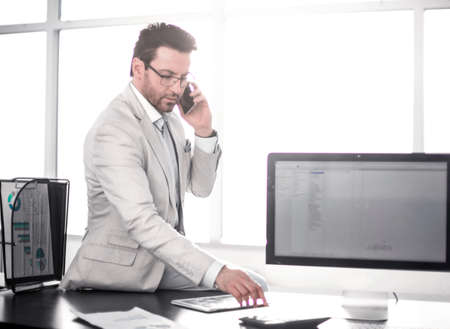 businessman uses his smartphone to discuss financial documents