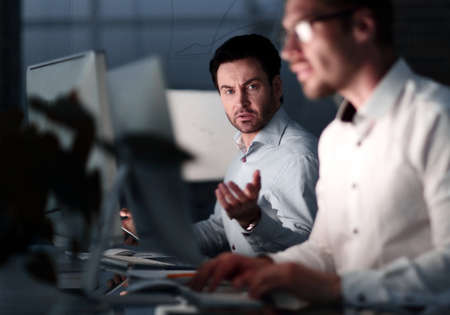 close up.two colleagues working at night in the office.の写真素材