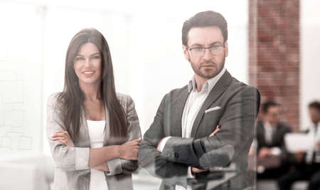 businessman and businesswoman look through the window of a modern officeの写真素材