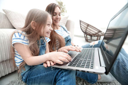 happy mother with adorable little girl with laptop