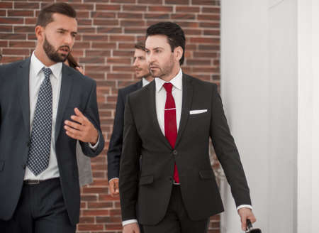business colleagues are discussing something, walking along the office corridor