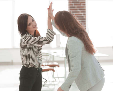 two young co-workers giving each other a high fiveの写真素材