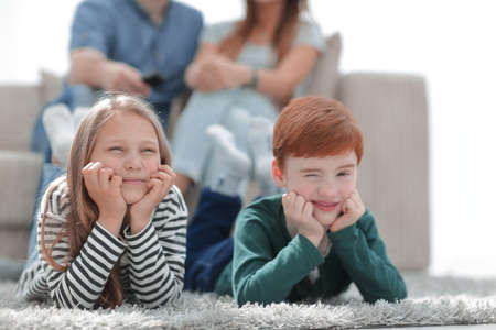 close up.little brother and sister lying on the carpet in the living roomの写真素材